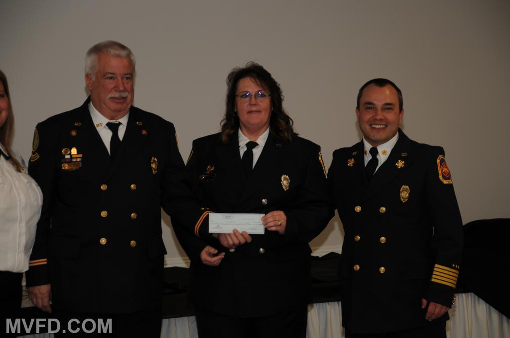 Outgoing Aux. President Karen Montgomery presenting President Montgomery and Chief Trowbridge with a check from the Auxiliary.