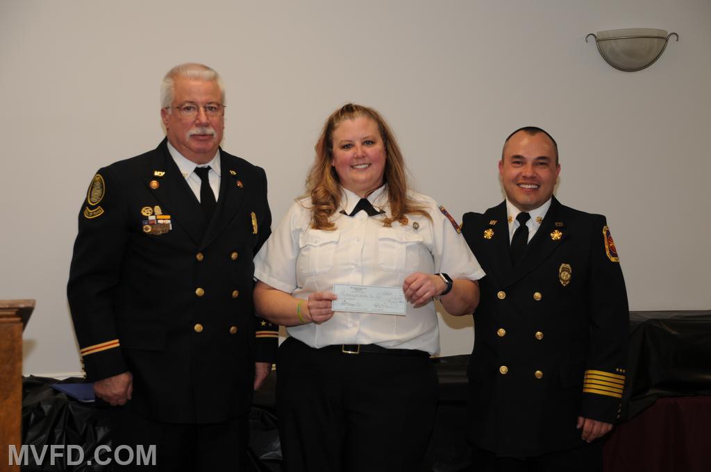 Auxiliary President Colonna presents a check to President Montgomery and Chief Trowbridge for $50,000.