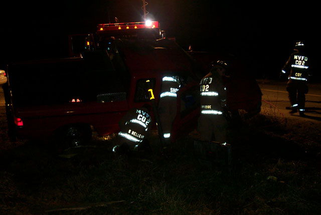 Firefighters assist EMS inside the vehicle before taking the door completely off